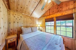 ein Schlafzimmer mit einem Bett in einer Holzhütte in der Unterkunft Seneca Lake Serenity in Hector