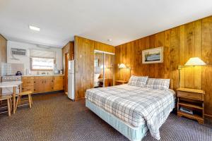 a bedroom with wooden walls and a bed and a kitchen at King Birch Lake Home, Unit 6 in Alton