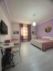 a bedroom with two beds and a table and a desk at CASA VACANZA BELVEDERE in Ercolano