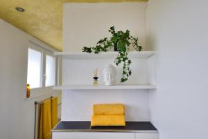 eine Küche mit weißen Regalen und einem gelben Handtuch in der Unterkunft Holiday Apartment NAMASTAY in Küssaberg