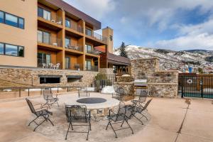 a patio with a table and chairs in front of a building at Snow Flower 206 in Steamboat Springs