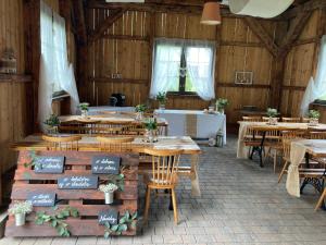 una sala da pranzo con tavoli, sedie e vasca di Chata Vojtkoland 