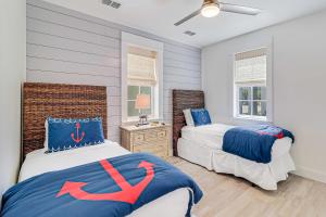 two beds in a bedroom with blue and white at Kahakai Retreat in Port Aransas