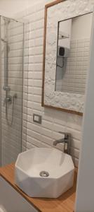 a bathroom with a white sink and a mirror at A un passo dal mare CIN ITO1OO59C29ZGY7FLN in Riva Trigoso