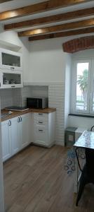 cocina con armarios blancos y suelo de madera en A UN PASSO DAL MARE, en Riva Trigoso