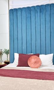 - un lit avec deux oreillers et une tête de lit bleue dans l'établissement Стильні Апартаменти на Ратушній площі, à Moukatcheve