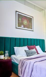 1 dormitorio con cabecero verde y 1 cama en Стильні Апартаменти на Ратушній площі, en Mukácheve