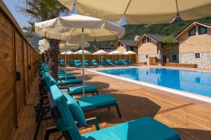 a swimming pool with lounge chairs and an umbrella at MUKHA ORMANLI in Ormanlı