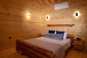 ein Schlafzimmer mit einem Bett in einem Blockhaus in der Unterkunft MUKHA ORMANLI in Ormanlı