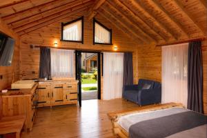 a bedroom in a log cabin with a bed and a desk at MUKHA ORMANLI in Ormanlı