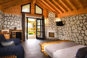 a bedroom with a bed and a stone wall at MUKHA ORMANLI in Ormanlı +79 photos