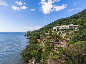 un bâtiment sur une falaise à côté de l'eau dans l'établissement Boca de Tomatlán Ocean Frontage Boutique Hotel, à Puerto Vallarta
