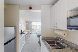 a kitchen with a sink and a refrigerator at Island Colony 3519 - 30 night minimum in Honolulu