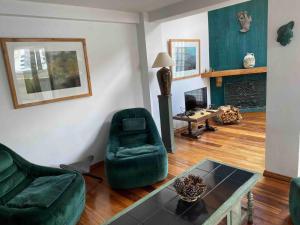 uma sala de estar com mobiliário verde e uma mesa em Garzonier Estilo Cabaña em La Paz
