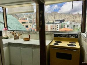 cocina con estufa amarilla y ventana en Garzonier Estilo Cabaña en La Paz