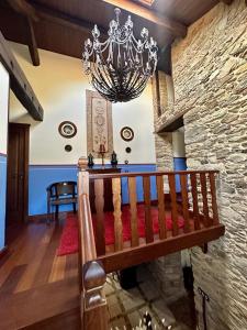 a living room with a chandelier and a wooden bench at Casa Almoina in Viveiro