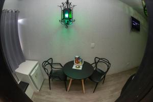 a dining room table with chairs and a chandelier at Manhattan Motel (Adult Only) in Porto Alegre