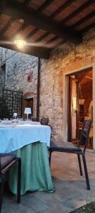 a table and chairs on a patio with a stone wall at I Salici Agriturismo in Badia Agnano