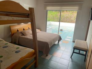 a bedroom with two bunk beds and a balcony at Hotel Familiar El Remanso Del Agua in Guatapé