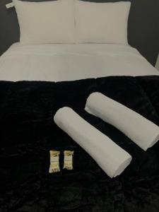 a bed with two pillows and two towels on it at Apartamento Passo Fundo in Passo Fundo