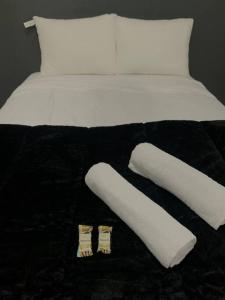 a bed with two white pillows and socks on it at Apartamento Passo Fundo in Passo Fundo