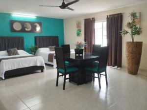a dining room with a table and chairs and a bedroom at Hotel San Miguel in Progreso
