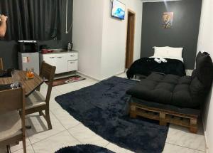 ein Wohnzimmer mit einem Sofa und einem Bett in der Unterkunft Apartamento Passo Fundo in Passo Fundo