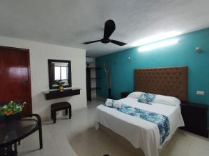 1 dormitorio con 1 cama y ventilador de techo en Hotel San Miguel, en Progreso