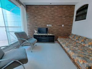 ein Wohnzimmer mit Sofa und Fernseher in der Unterkunft Descanso a beira mar casa completa em Mambucaba in Tarituba