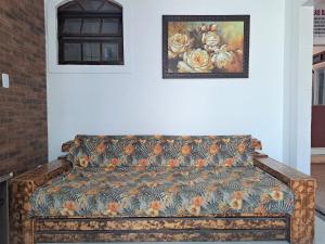 eine Couch in einem Zimmer mit einem Gemälde an der Wand in der Unterkunft Descanso a beira mar casa completa em Mambucaba in Tarituba