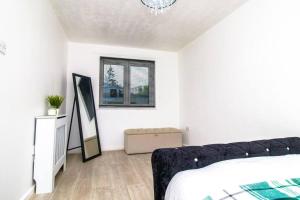 a white bedroom with a bed and a window at Shazeal Apartments in Birmingham