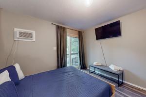 a bedroom with a blue bed and a tv at Brentwood Burrow in East Stroudsburg