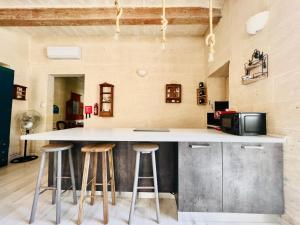 a kitchen with a counter and two stools at COFFEE LOFT - Grand Master Palace in Valletta