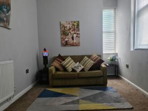 a living room with a couch and a rug at Cozy apartment 1 in Worcester