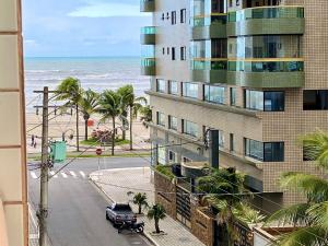 um edifício na praia com um carro estacionado ao lado em Residencial Santo Expedido na Praia Grande