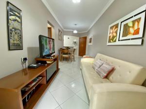 uma sala de estar com um sofá e uma televisão em Residencial Santo Expedido na Praia Grande