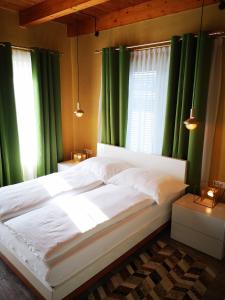 a bedroom with a large bed with green curtains at Aparthotel "Goldener Hahn Apartments" in Bad Waltersdorf
