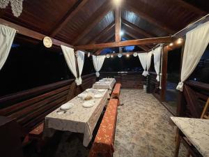 a dining room with a long table in a house at Pensiunea Nituca in Moisei