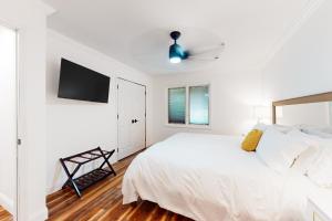 1 dormitorio blanco con 1 cama y TV de pantalla plana en The Happy Place on Lake Avalon, en Bella Vista