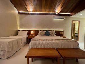 a bedroom with two beds and a wooden ceiling at Pousada Naonda in Fernando de Noronha