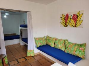 a living room with a blue couch and a mirror at Kitchenette Charmosa no Itagua in Ubatuba