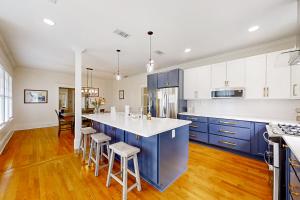 una cocina con armarios azules y una isla de cocina con taburetes en Sydney Spring - Unit A en Jacksonville