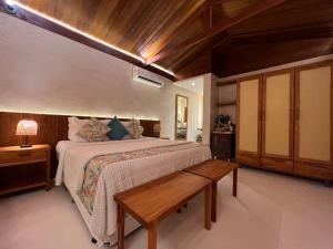 a bedroom with a large bed and a wooden ceiling at Pousada Naonda in Fernando de Noronha