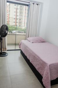 a bedroom with a bed and a large window at Apto 2 qts, wifi, netflix, metrô próximo in Brasília