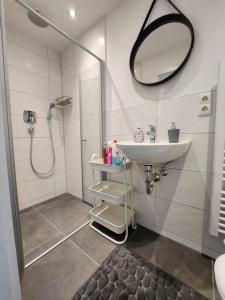 a bathroom with a shower and a sink and a mirror at Cozy Apartment with WIFI, Near University&Hospital in Augsburg