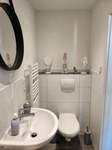a white bathroom with a toilet and a sink at Cozy Apartment with WIFI, Near University&Hospital in Augsburg