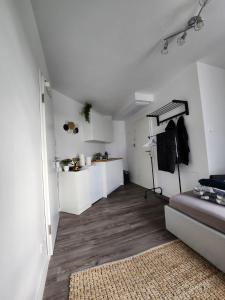 a kitchen with white cabinets and a wooden floor at Cozy Apartment with WIFI, Near University&Hospital in Augsburg