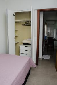 a bedroom with a bed and a room with a chair at Apto 2 qts, wifi, netflix, metrô próximo in Brasília