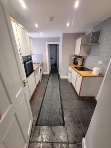 a kitchen with white cabinets and a hallway at 2 Kilkerran Road in Campbeltown