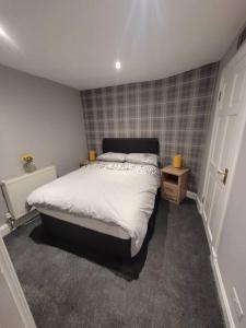 a bedroom with a large bed and a door at 2 Kilkerran Road in Campbeltown